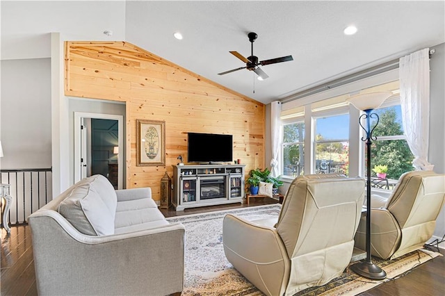 living room with wood walls, lofted ceiling, recessed lighting, dark wood-style floors, and a ceiling fan