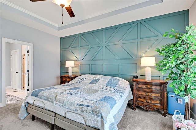 carpeted bedroom with crown molding, a decorative wall, and a tray ceiling