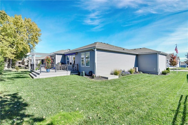 back of house featuring a lawn and a pergola