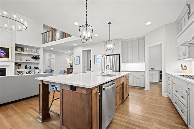 12745 N Larkspur Ln, Platte City, MO 64079 - kitchen with appliances with stainless steel finishes, open floor plan, a notable chandelier, and a sink