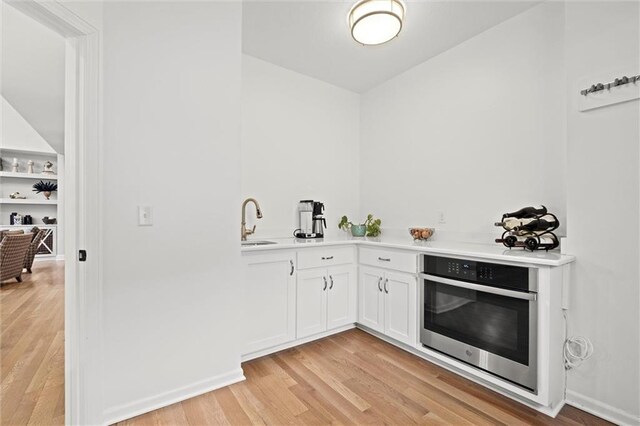 12745 N Larkspur Ln, Platte City, MO 64079 - bar with light wood-style floors, stainless steel oven, and a sink