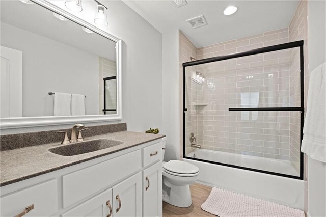 12745 N Larkspur Ln, Platte City, MO 64079 - full bath featuring enclosed tub / shower combo, wood finished floors, visible vents, toilet, and vanity