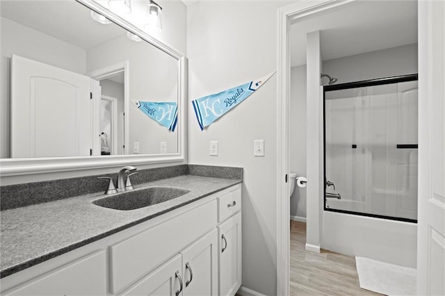 12745 N Larkspur Ln, Platte City, MO 64079 - bathroom with baseboards, wood finished floors, bath / shower combo with glass door, and vanity