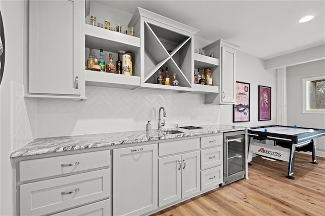 12745 N Larkspur Ln, Platte City, MO 64079 - bar featuring wine cooler, light wood-style flooring, a sink, tasteful backsplash, and wet bar