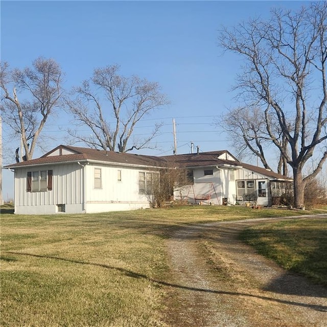 view of front of property with board and batten siding and a front lawn