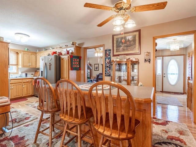 dining area with light wood-type flooring and ceiling fan