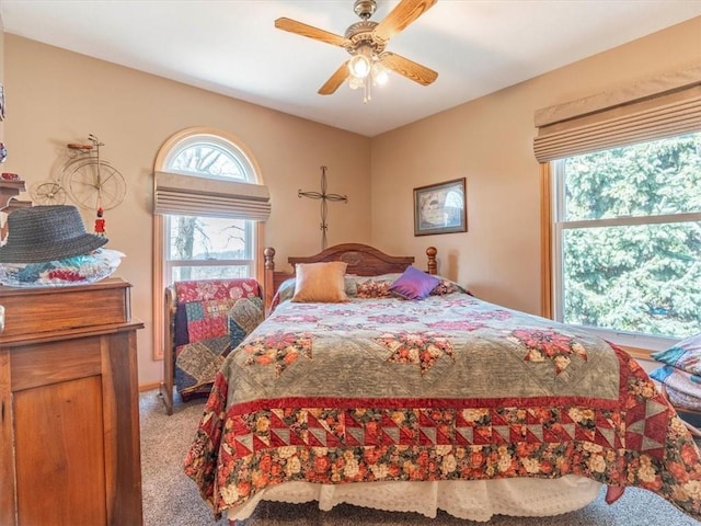 bedroom with a ceiling fan and light colored carpet