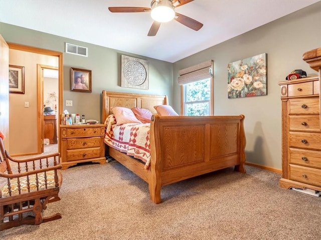 bedroom featuring ceiling fan, light colored carpet, visible vents, and baseboards