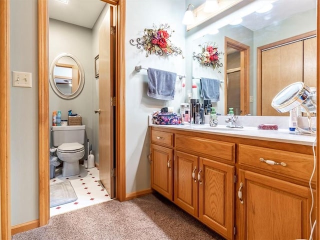 bathroom with vanity, toilet, and carpet