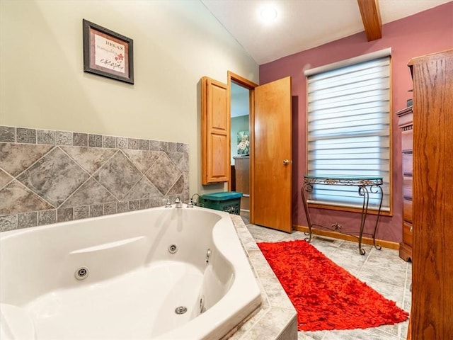 bathroom featuring tile patterned flooring, a jetted tub, and baseboards