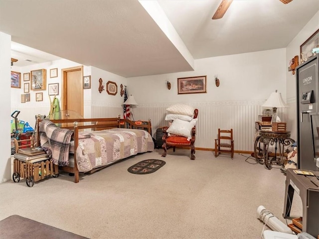 bedroom with wainscoting, carpet, and ceiling fan