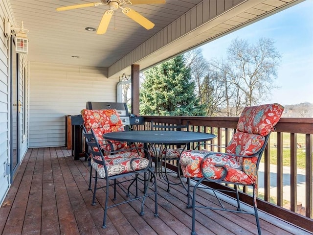 deck with outdoor dining space and a ceiling fan