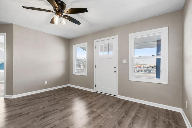 foyer featuring ceiling fan, baseboards, and dark wood-style flooring