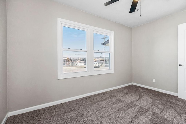 carpeted empty room with ceiling fan and baseboards