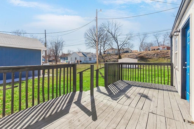 wooden deck with an outbuilding, a residential view, a storage shed, and a yard