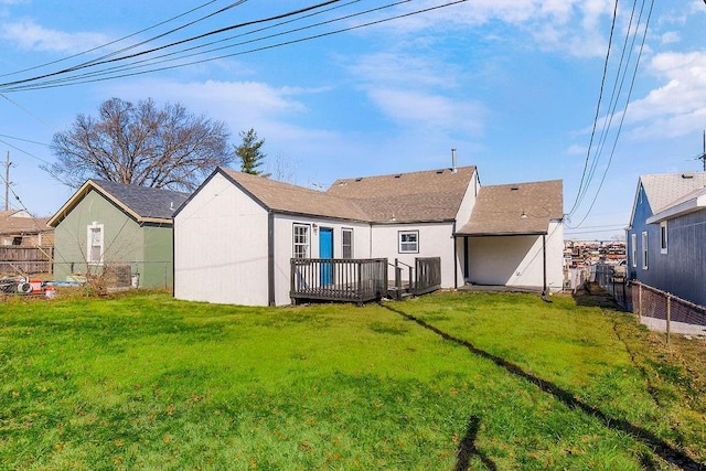 back of property featuring a deck, a lawn, and a fenced backyard