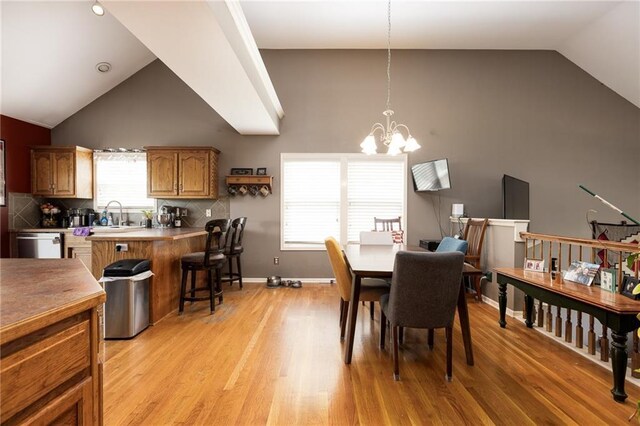 8755 N Chatham Ave, Kansas City, MO 64154 - dining area featuring vaulted ceiling, a chandelier, and light wood finished floors