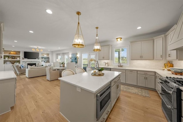 9010 N Denver Ave, Kansas City, MO 64156 - kitchen featuring open floor plan, light wood-style flooring, appliances with stainless steel finishes, and light countertops