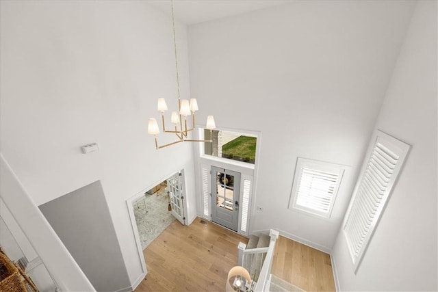 9010 N Denver Ave, Kansas City, MO 64156 - entrance foyer with light wood-type flooring, a notable chandelier, visible vents, and a towering ceiling