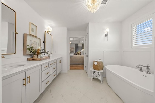 9010 N Denver Ave, Kansas City, MO 64156 - ensuite bathroom with double vanity, a freestanding bath, a decorative wall, marble finish floor, and a sink