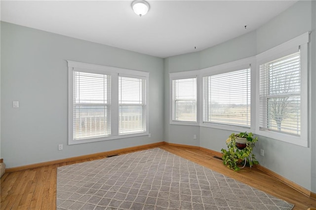 empty room with visible vents, baseboards, and light wood-type flooring