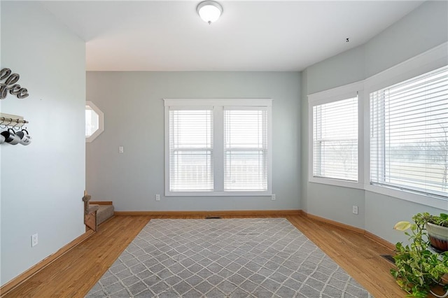 unfurnished room featuring baseboards and light wood finished floors