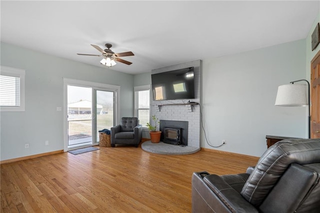 living room featuring visible vents, light wood-style flooring, baseboards, and ceiling fan