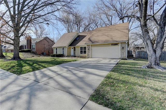 view of front facade featuring a front yard, concrete driveway, an attached garage, and fence