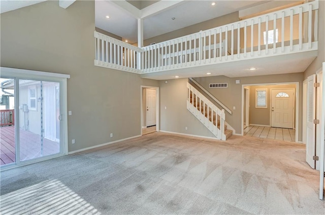 unfurnished living room featuring stairway, visible vents, baseboards, and carpet floors