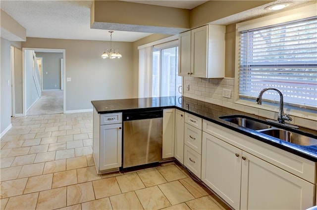 kitchen with a sink, stainless steel dishwasher, a peninsula, white cabinets, and decorative backsplash