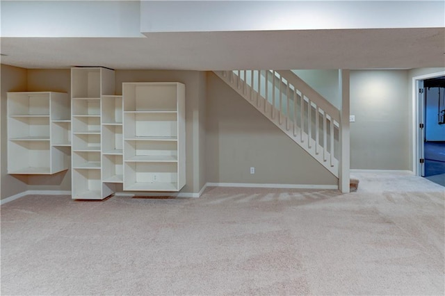 unfurnished living room with baseboards, carpet floors, and stairs