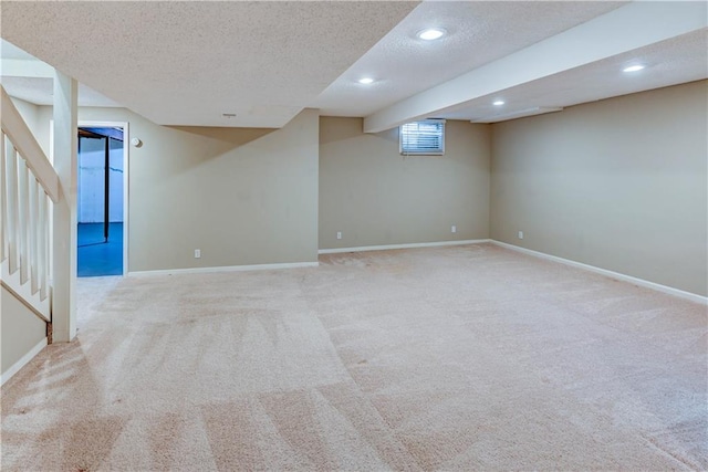 basement featuring baseboards, recessed lighting, stairs, a textured ceiling, and carpet flooring