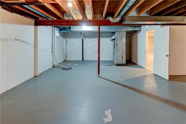 unfinished basement featuring heating unit