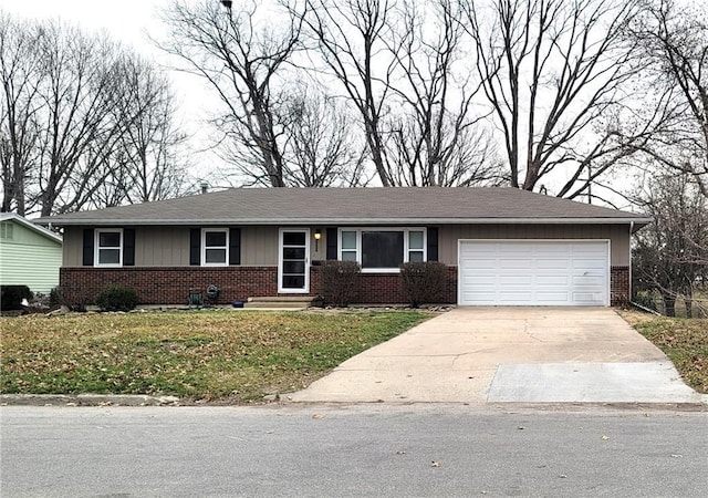 single story home featuring a front yard, brick siding, an attached garage, and driveway