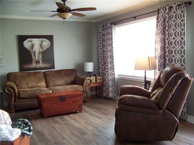 living area with a wealth of natural light, wood finished floors, ornamental molding, and a ceiling fan