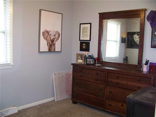 carpeted bedroom with visible vents, multiple windows, and baseboards