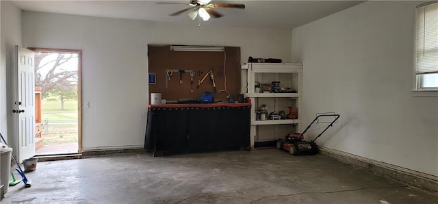 interior space with unfinished concrete floors and a ceiling fan