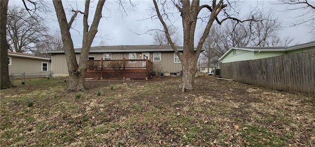 rear view of house featuring a deck and fence