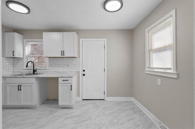 3403 Norton Ave, Kansas City, MO 64128 - kitchen featuring decorative backsplash, baseboards, marble finish floor, and a sink