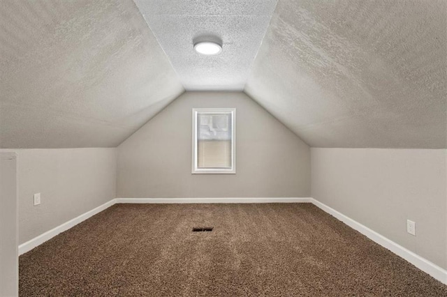 3403 Norton Ave, Kansas City, MO 64128 - bonus room featuring carpet flooring, a textured ceiling, baseboards, and vaulted ceiling