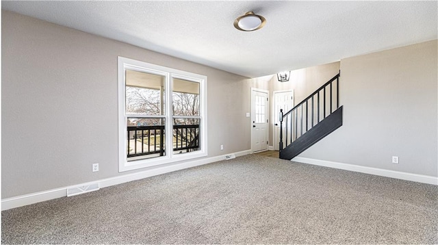 entryway featuring visible vents, baseboards, stairway, carpet flooring, and a textured ceiling