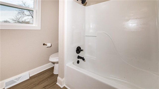 bathroom with visible vents, toilet, shower / tub combination, wood finished floors, and baseboards