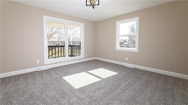 empty room featuring visible vents, carpet flooring, and baseboards