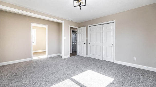 unfurnished bedroom with a closet, baseboards, and carpet