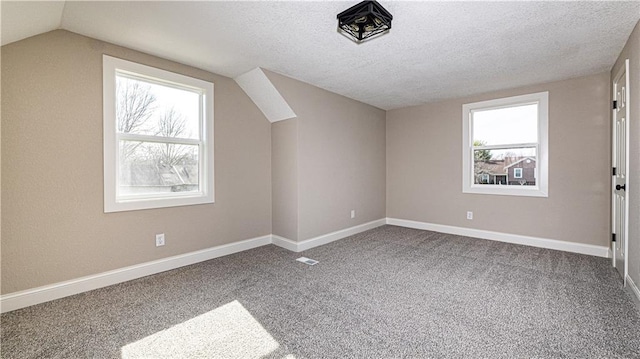 bonus room featuring baseboards, a textured ceiling, carpet flooring, and vaulted ceiling