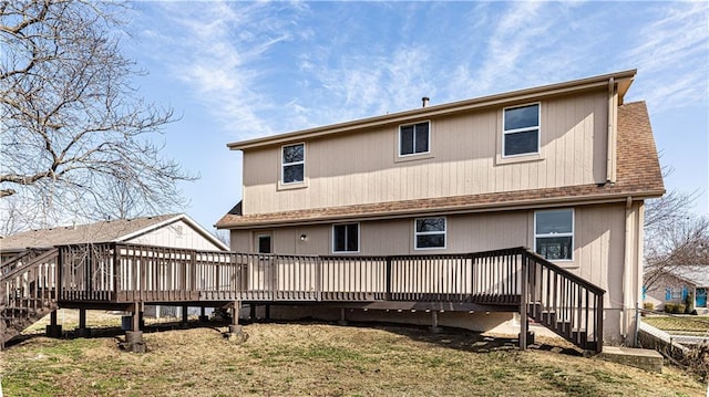 rear view of property with a deck, stairway, and roof with shingles