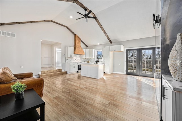 living room with a wealth of natural light, visible vents, light wood-type flooring, and ceiling fan