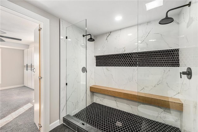 full bathroom with a marble finish shower, ceiling fan, and baseboards