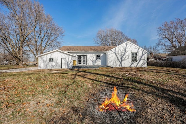 back of property featuring french doors, a fire pit, and a yard