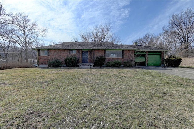 single story home with aphalt driveway, a front yard, brick siding, and an attached garage